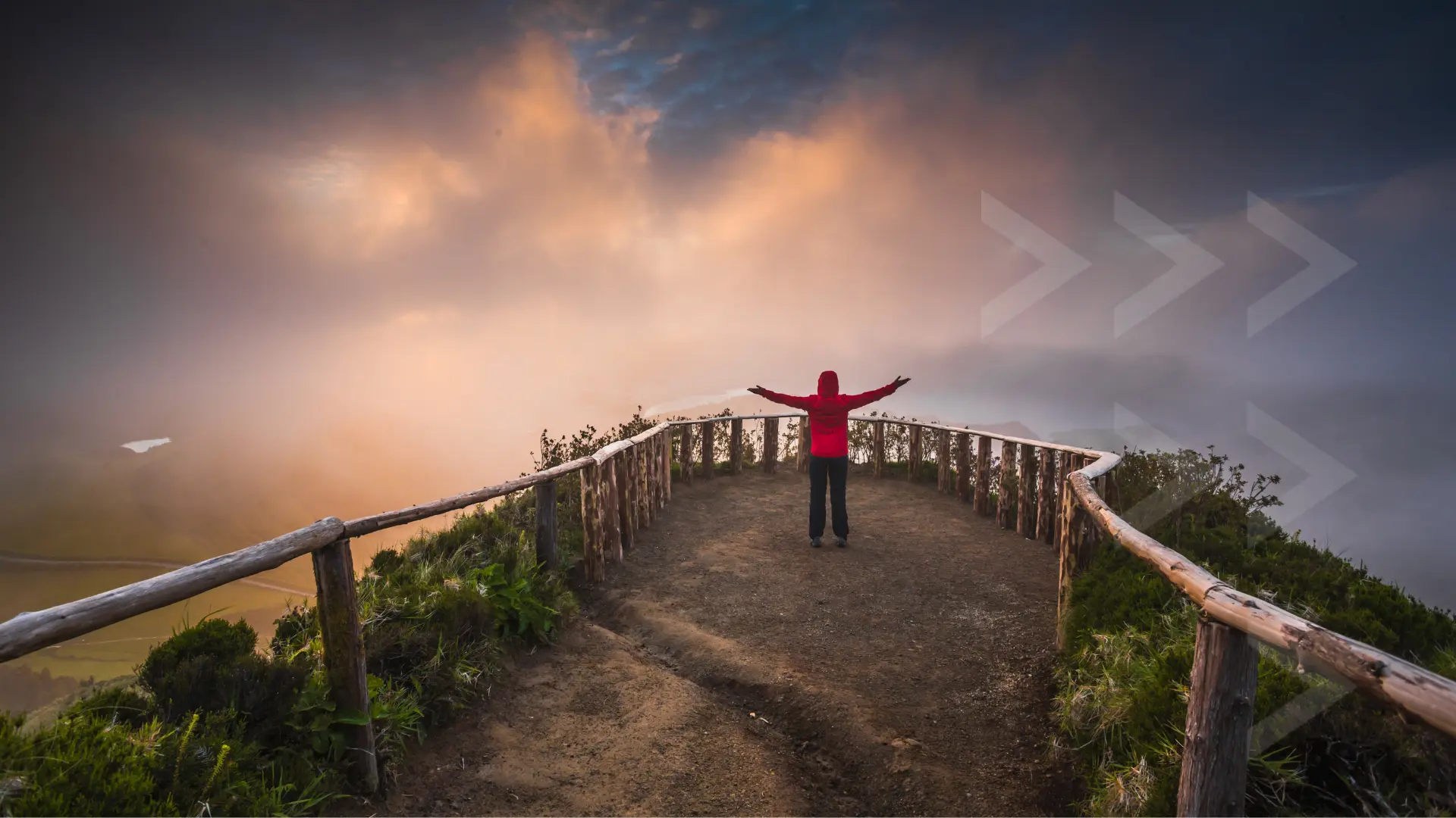 Person with arms raised on wooden bridge