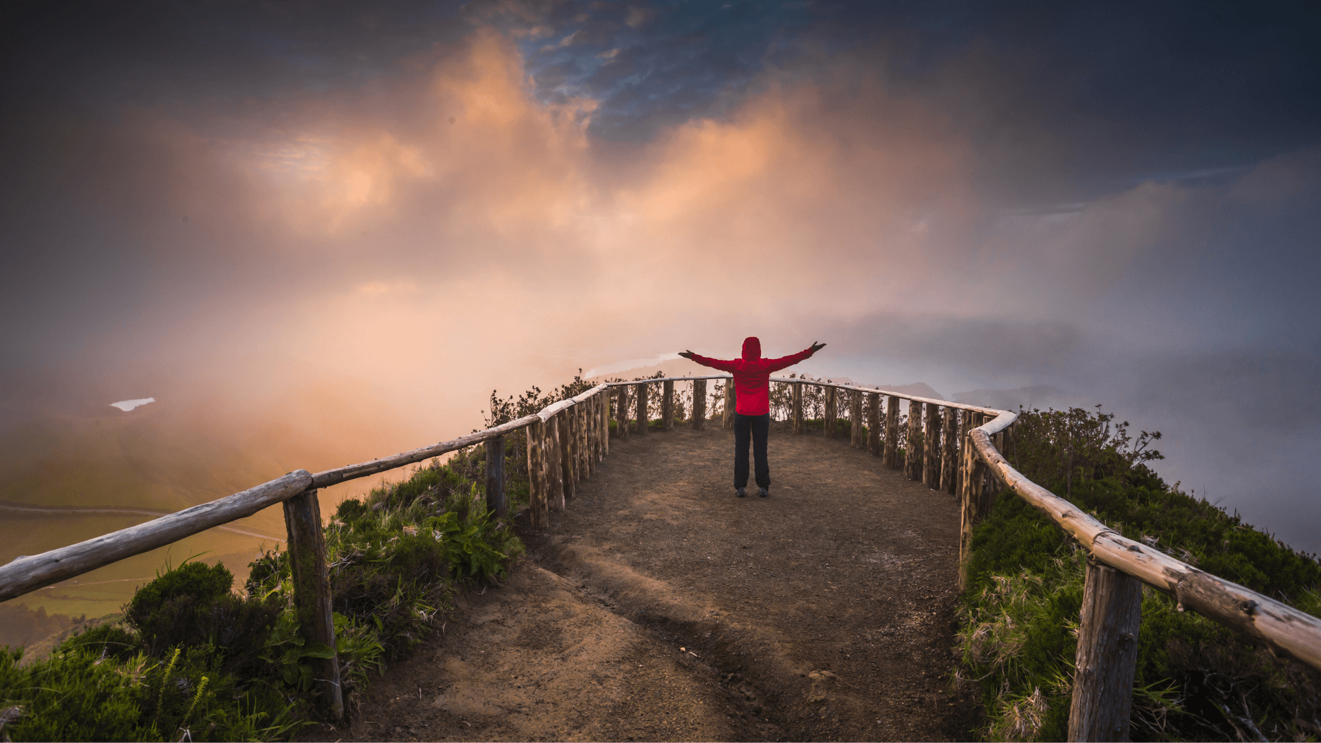 Person with arms raised on wooden bridge